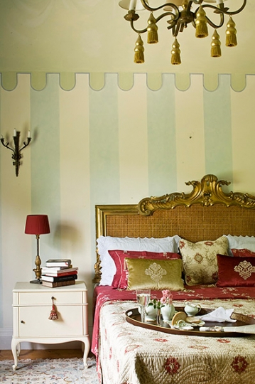 Sypialnia z rattanowym, złoconym zagłówkiem. Projekt wnętrza KANACH INTERIORS