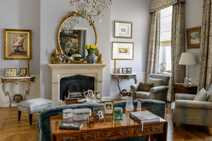 Salon. Kominek z pińczowskiego wapienia ze złoconym atycznym lustrem, włoskie konsole barokowe, zasłony uszyte z tkaniny Zoffany,  . Projekt wnętrza KANACH INTERIORS