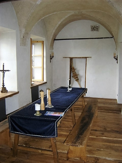 Jadalnia w XV-wiecznej kamienicy. Ręcznie zacierane tynki, stary, prosty stół i ławki.  Projekt wnętrza KANACH INTERIORS .