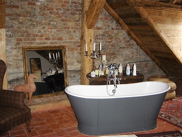 Łazienka w XV wiecznej kamienicy (Dom Wikariuszy). Wanna angielska na tle murowanej ściany. Projekt wnętrza KANACH INTERIORS