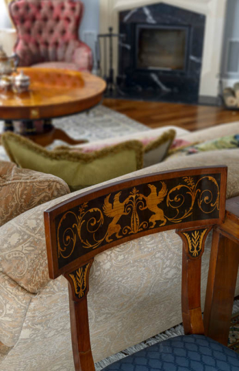 Salon w stylu klasycznym pełen antyków, kamienny portal kominkowy, intarsjowane krzesło antyczne, projektowanie wnętrz ponadczasowych, projektowanie wnętrz stylowych, projektowanie wnętrz klasycznych.