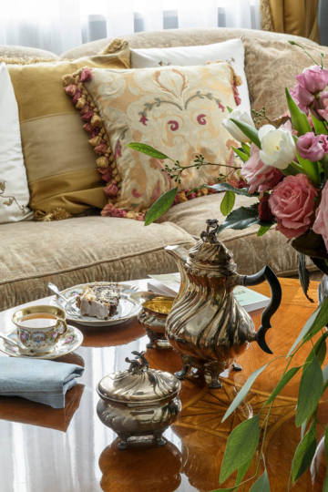 Salon w stylu klasycznym pełen antyków, sofa na zamówienie, poduszki dekoracyjne szyte na zamówienie, intarsjowana ława do sofy, projektowanie wnętrz ponadczasowych, projektowanie wnętrz stylowych, projektowanie wnętrz klasycznych.