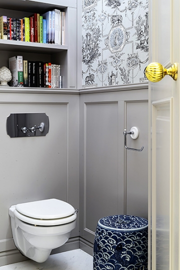 WC, nad geberitem półka na książki i dodatki. Malowany paneling i francuska tapeta z wzorem historycznym. Projekt KANACH INTERIORS