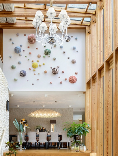 Widok na jadalnię i kolorowe rzeźbione kule. Projekt wnętrza KANACH INTERIORS